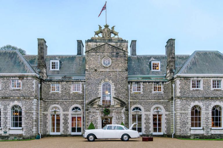 Photo of the front of Farleigh Wallop with a Bentley outside