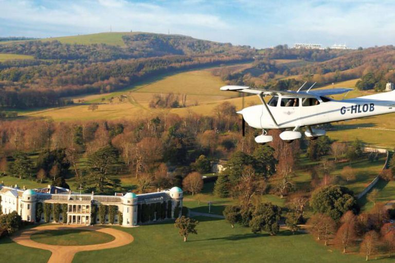 Photo of a plane flying over Goodwood House